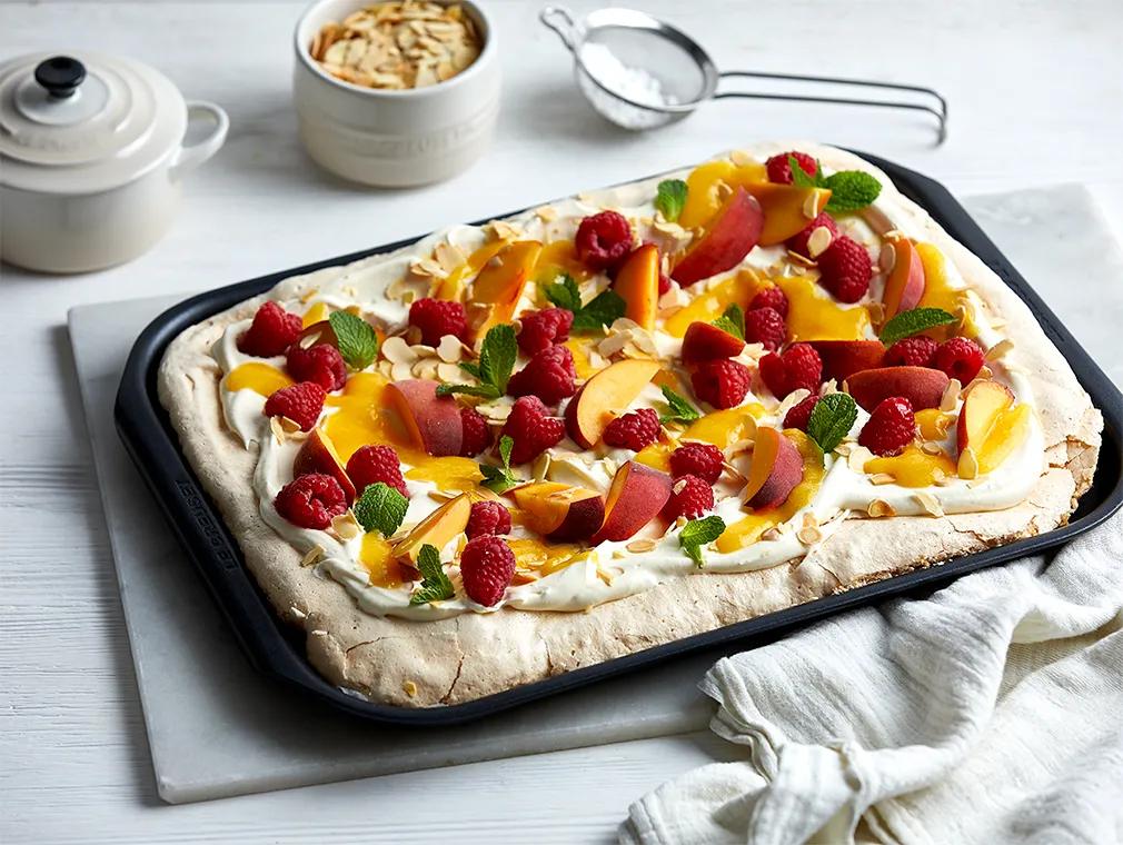 Mandelpavlova med coulis på persika, mascarponekräm och färsk frukt
